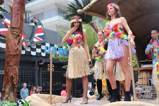 Women in grass skirts and flower garlands on a float, 2019