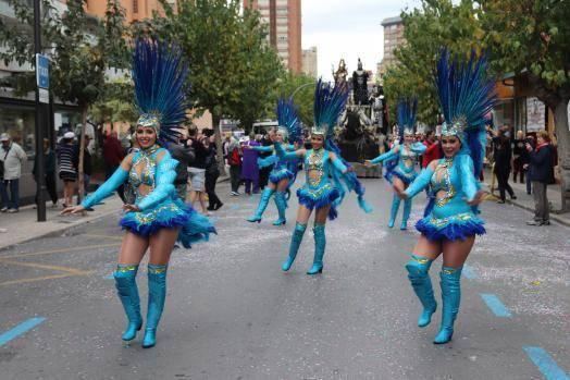 Samba dancers in blue feathered costumes dancing down the street, 2019