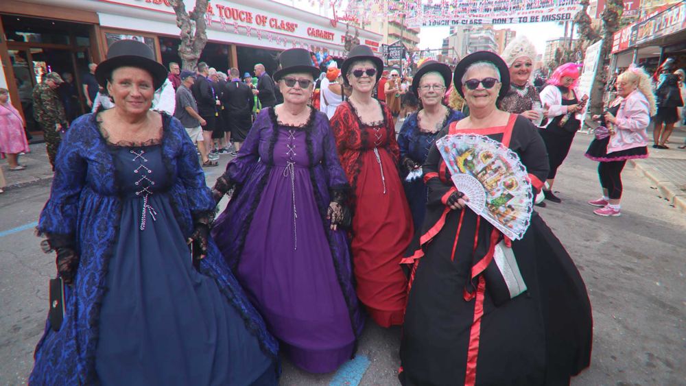 Five women in full Victorian ball gowns and top hats, 2023