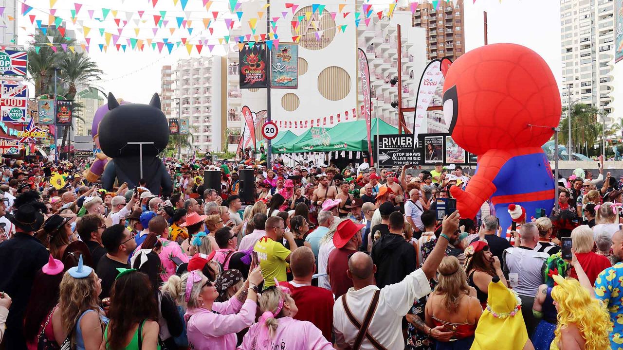Crowds on Calle Gerona with a giant Spider-Man inflatable, 2025