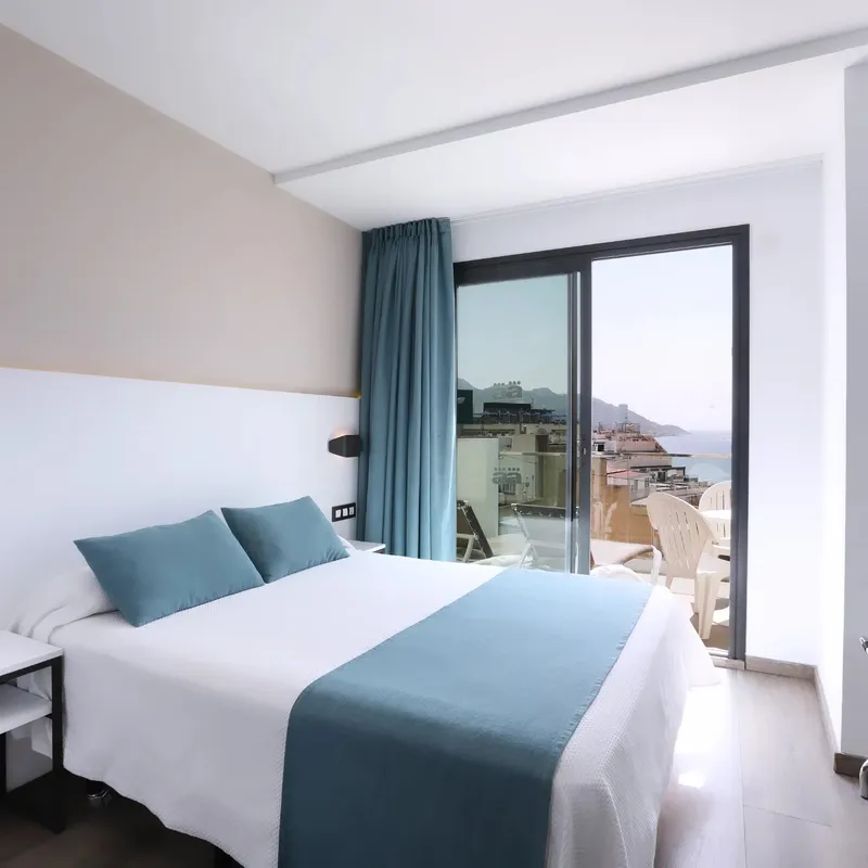 Alameda: Double room, Double bed with blue throw and balcony doors
