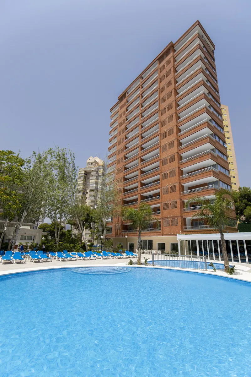 Levante Lux: Pool and tower, Large pool with loungers below the brick apartment tower
