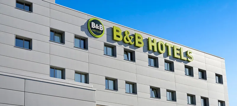 B&B Finestrat: The hotel, White hotel facade with green B&B Hotels sign against blue sky