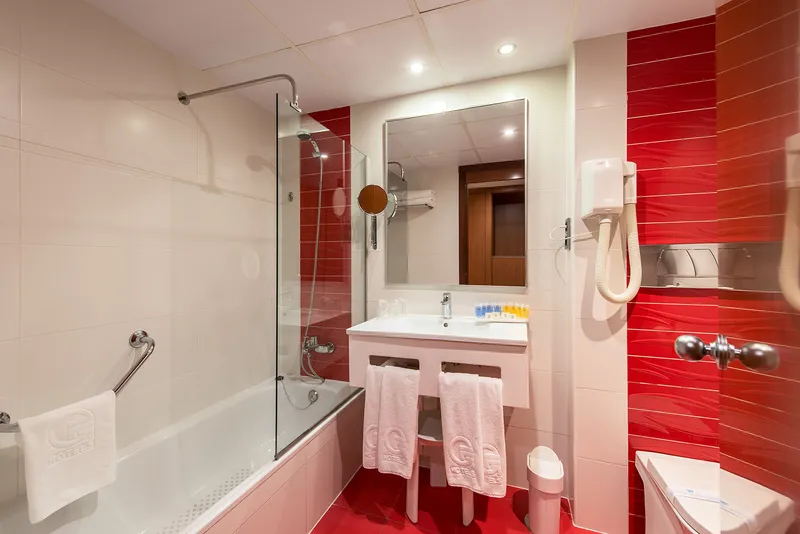 Benidorm Plaza: Bathroom, Bath with shower screen, red tiled wall and basin
