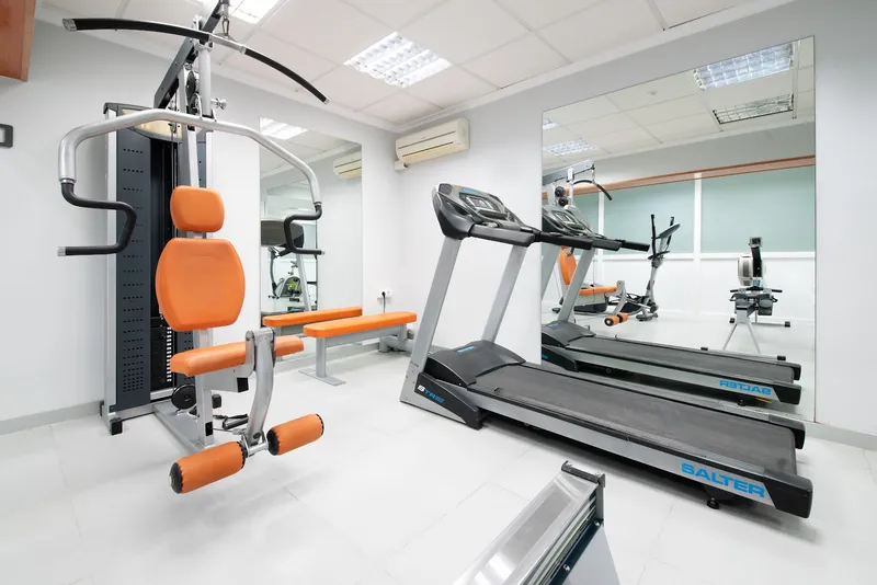 Brisa: Gym, Treadmills and weights machine in a mirrored room