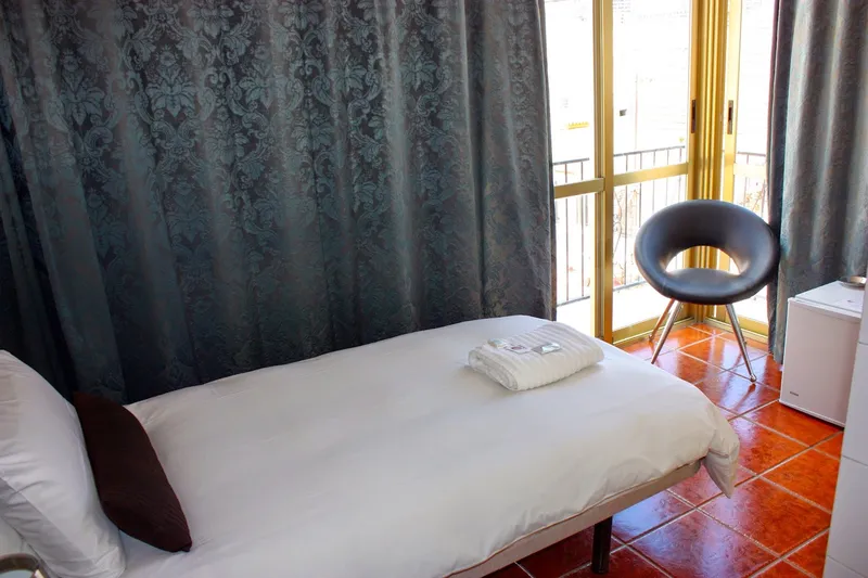 Casa Don Juan: Single room, Bed and chair beside balcony doors