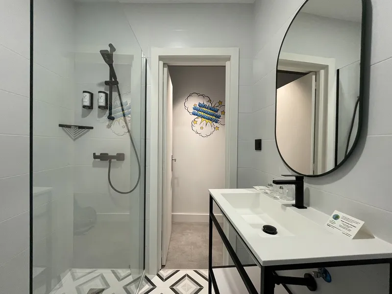 Casual Pop Art: Bathroom, Glass shower, round mirror and black-framed basin