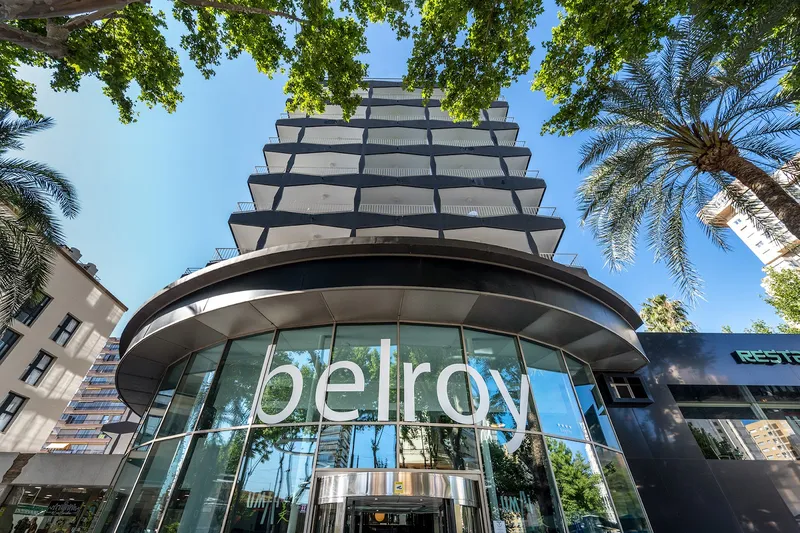 Belroy: The hotel, Curved glass entrance with Belroy sign under palm trees