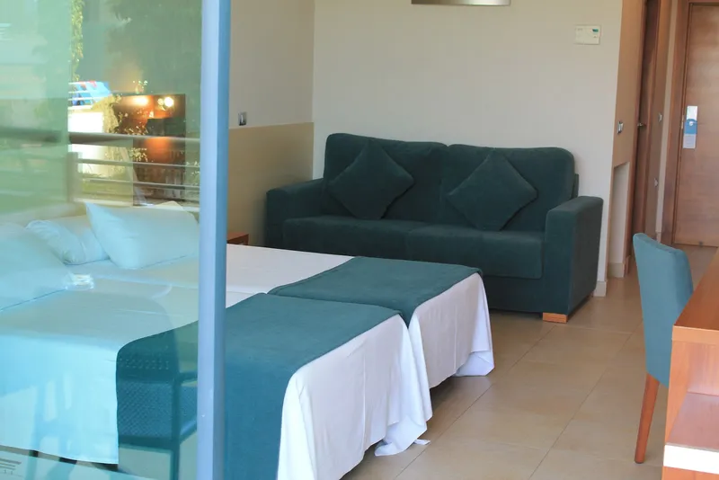 Deloix: Twin room, Twin beds with green throws and a matching sofa