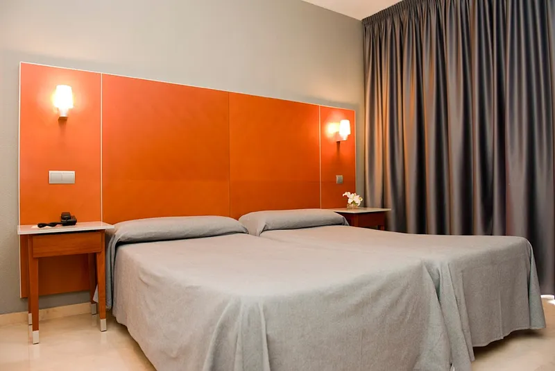 El Palmeral: Twin room, Twin beds with an orange headboard and grey curtains