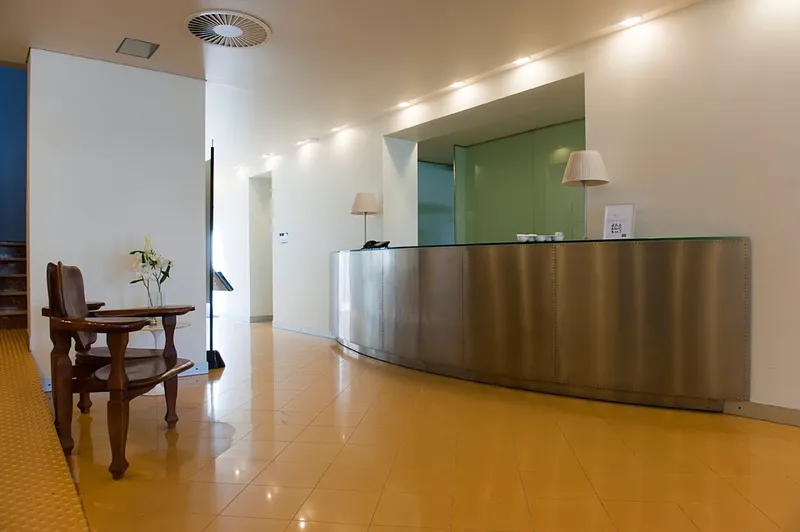 El Palmeral: Reception, Curved steel reception desk in a bright lobby