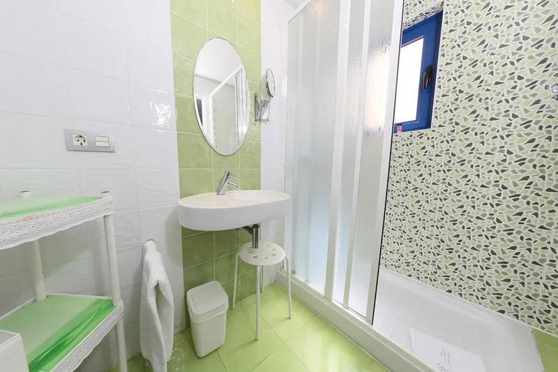 Fetiche: Bathroom, Green-tiled bathroom with shower and round mirror