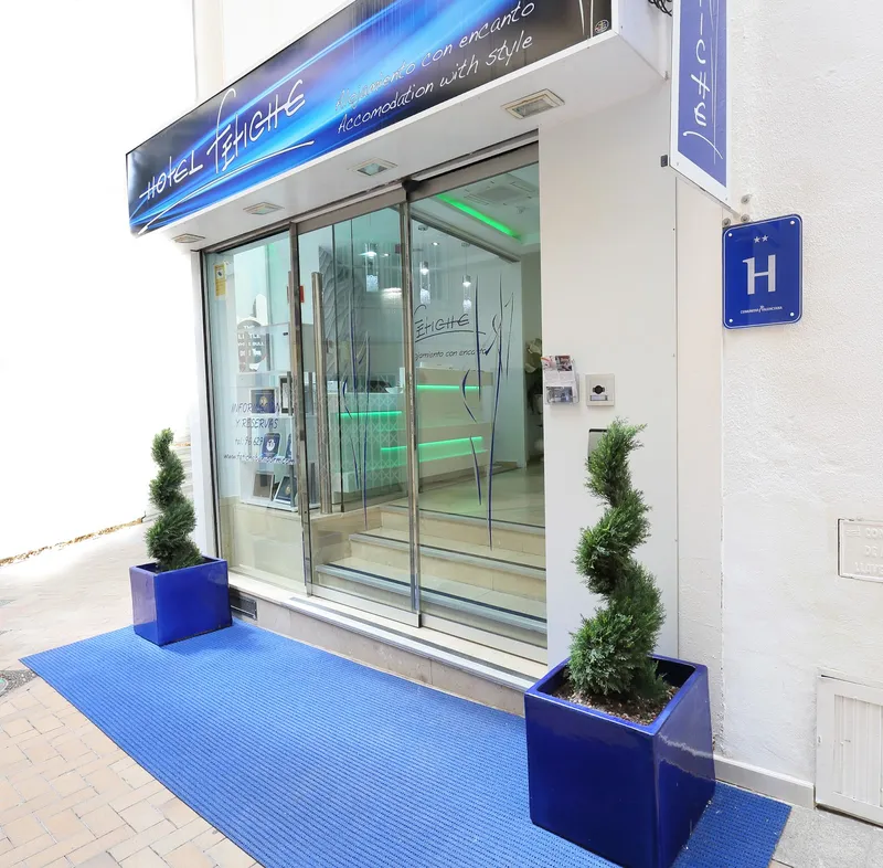 Fetiche: Entrance, Glass entrance with topiary pots and a blue mat