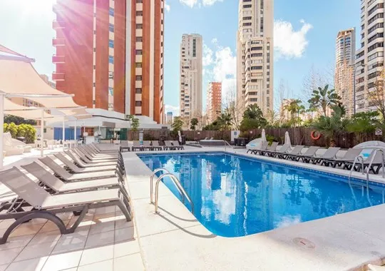 Flamingo: Pool, Pool with loungers and parasols among tower blocks