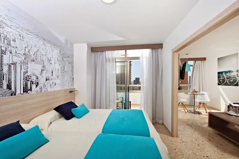 Flamingo: Twin room, Twin beds with turquoise throws and city mural