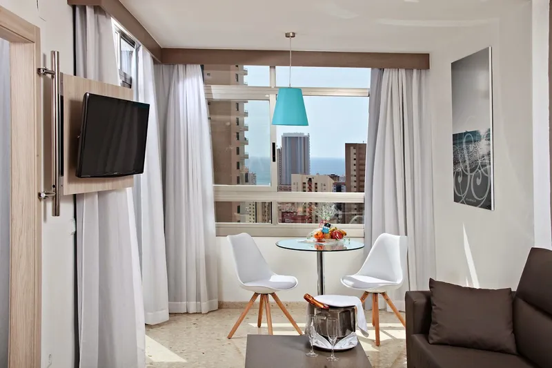 Flamingo: Lounge, Sitting area with table, chairs and wall TV by the window