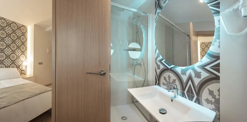 RH Canfali: Bathroom, Basin with lit round mirror and patterned tiles