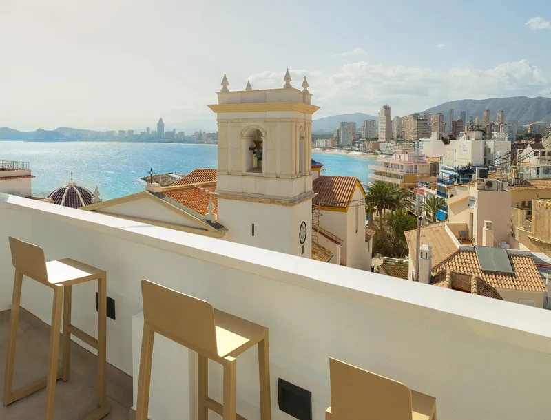 RH Canfali: Terrace view, Bar stools facing a bell tower and the bay