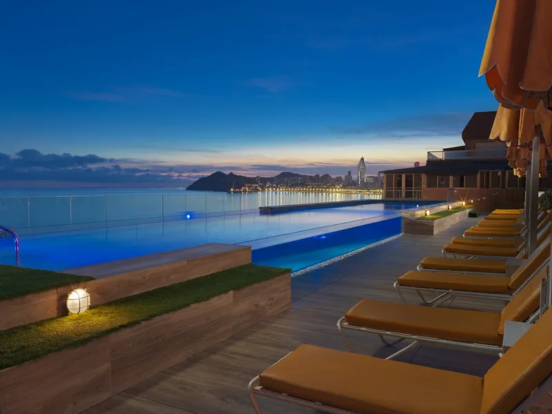 Porto Poniente: Pool at dusk, Infinity-edge pool and loungers in evening light