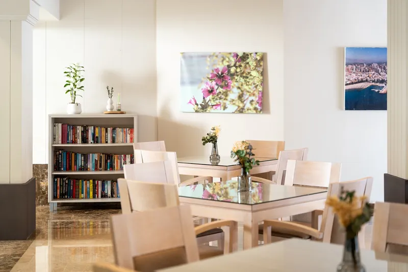 Helios: Lounge, Tables and chairs beside a bookcase