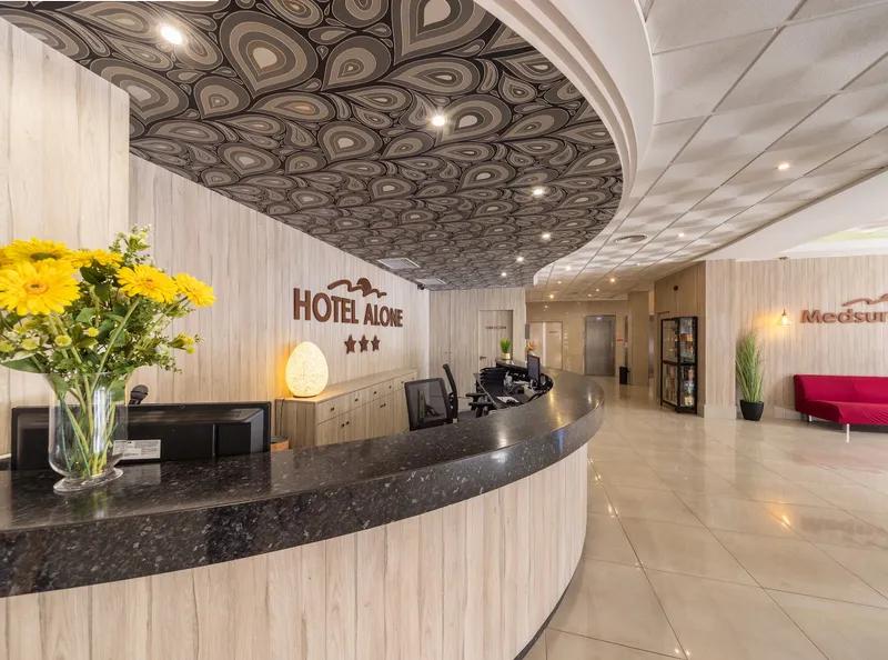 Medsur Alone: Reception, Curved reception desk with Hotel Alone sign and flowers