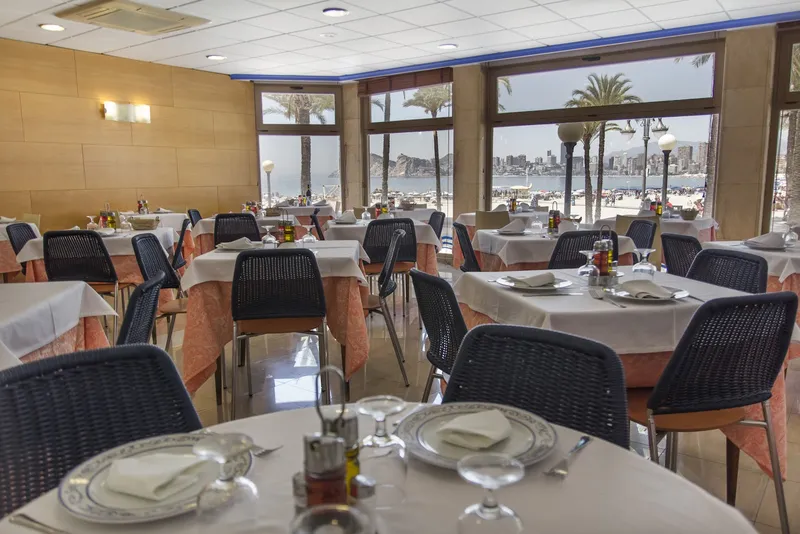 Colón: Dining room, Set tables by wide windows looking out to palms and the sea