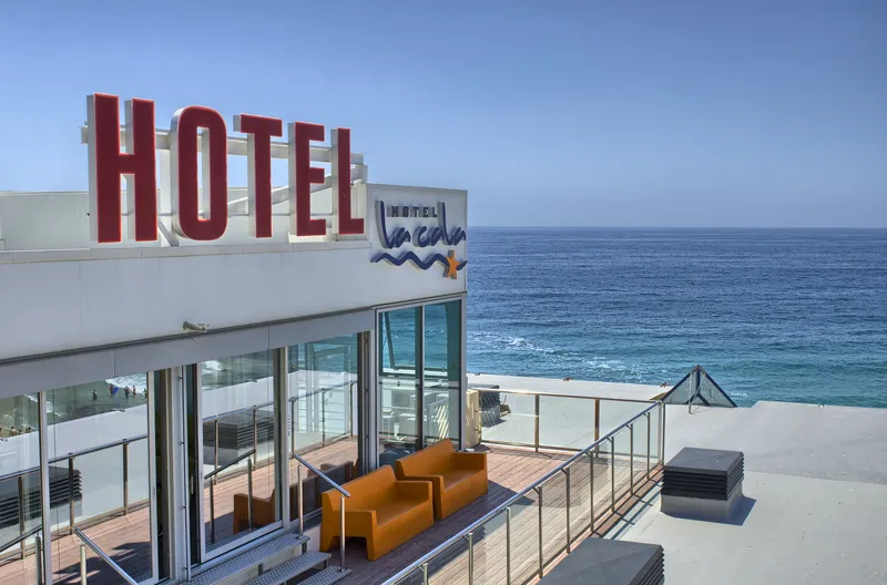 La Cala: Rooftop terrace, Hotel sign and terrace sofas facing the sea