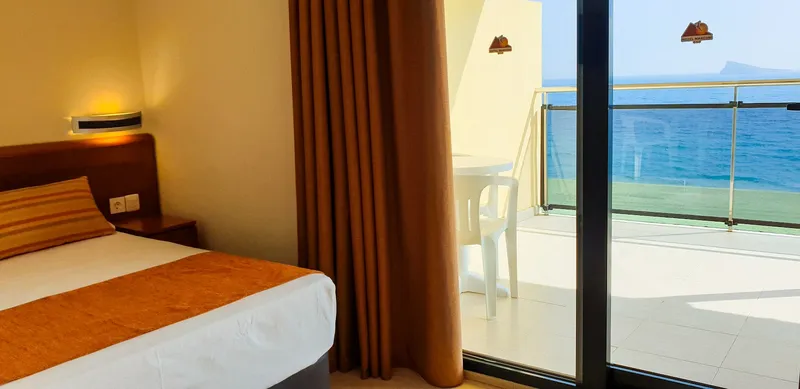 Marconi: Sea-view room, Bed beside glass doors to a balcony over the sea