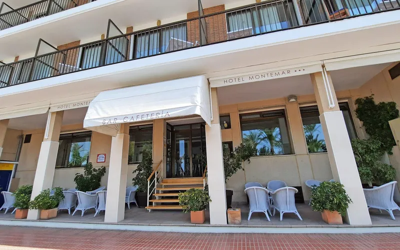 Montemar: Hotel entrance, Arcaded frontage with cafeteria awning and wicker chairs