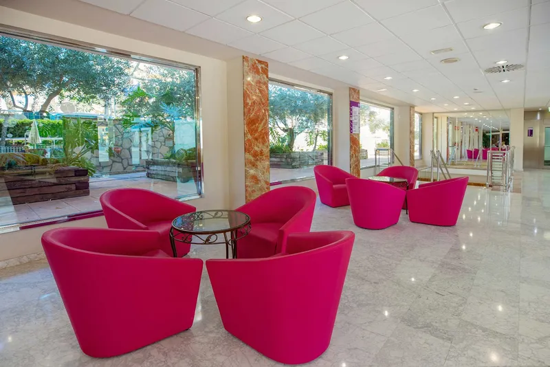 Venus: Lounge, Pink tub chairs in a bright lounge with garden windows