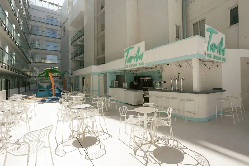 Villa España: Atrium bar, Bar counter and white chairs in a bright atrium