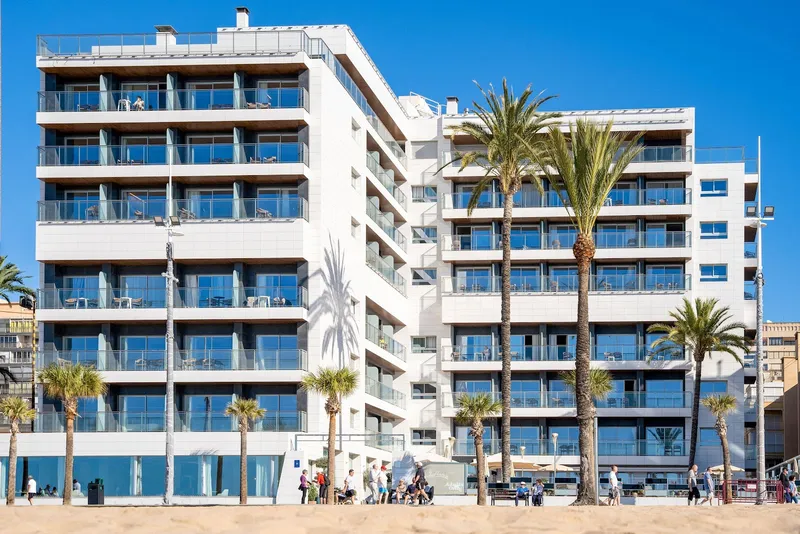 INNSiDE Costablanca: The hotel, White hotel blocks with balconies behind palms on the seafront