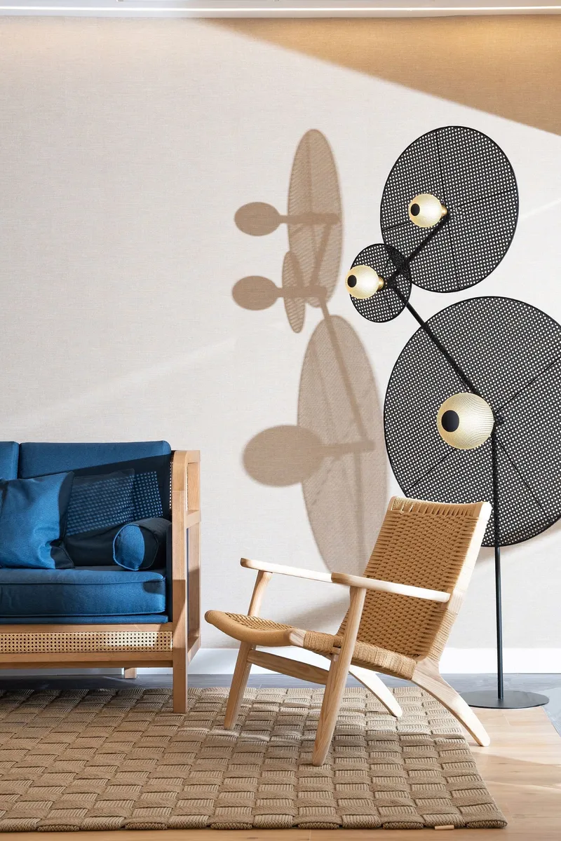 INNSiDE Costablanca: Lounge corner, Blue sofa and wooden armchair below a wall lamp