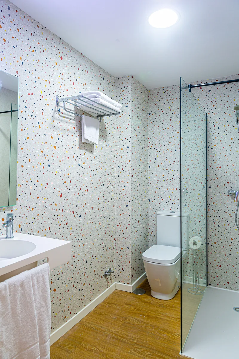 Internacional: Bathroom, Speckled-tile bathroom with glass shower screen