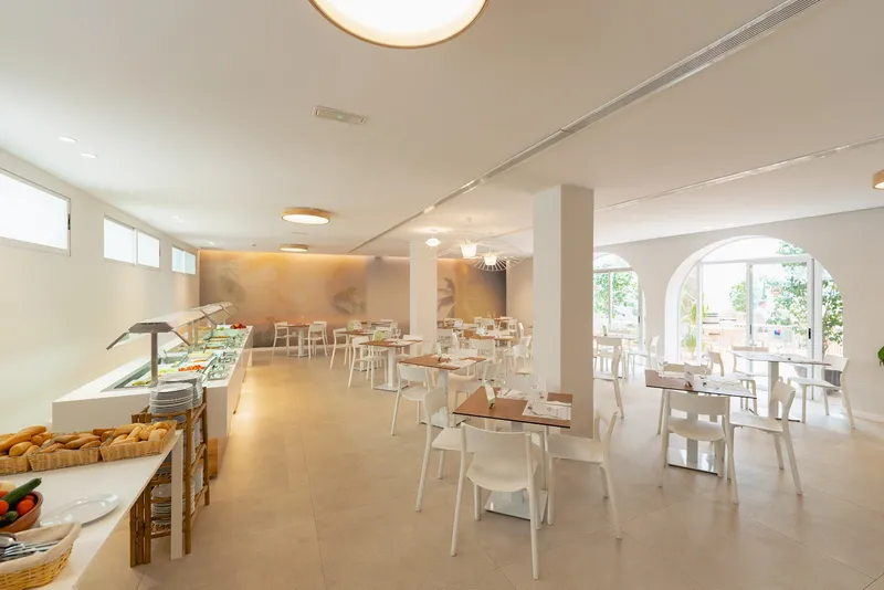 Internacional: Buffet restaurant, Buffet counter and white tables in a bright dining room