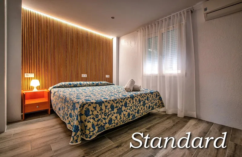 Irati: Double room, Double bed with patterned cover and wood-panelled wall
