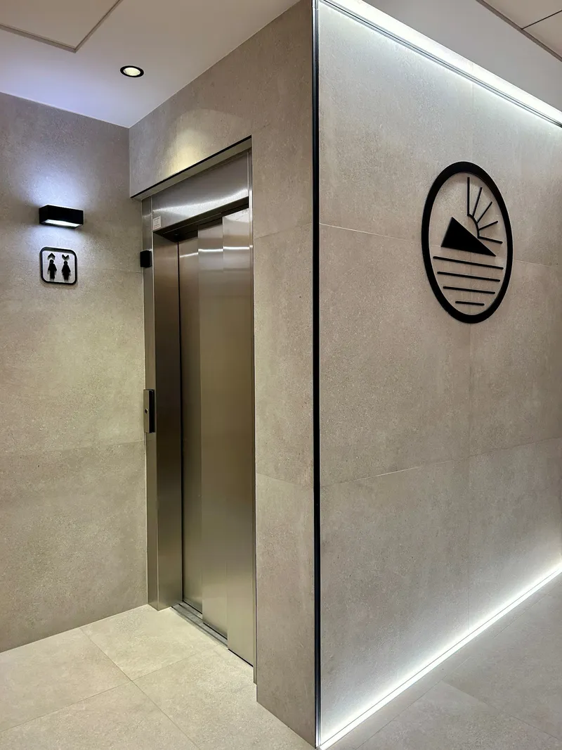 La Orozca: Lift, Lift doors in a tiled hallway