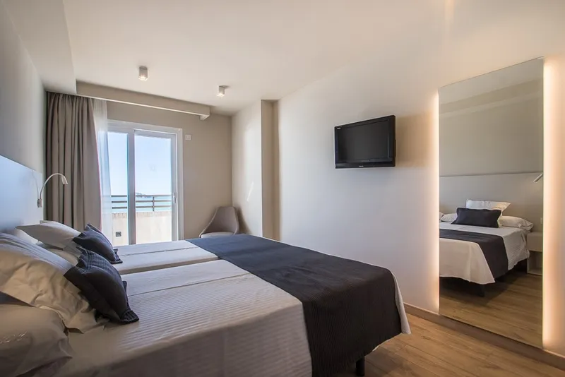 Les Dunes Comodoro: Twin room, Twin beds with dark throws, TV and balcony door