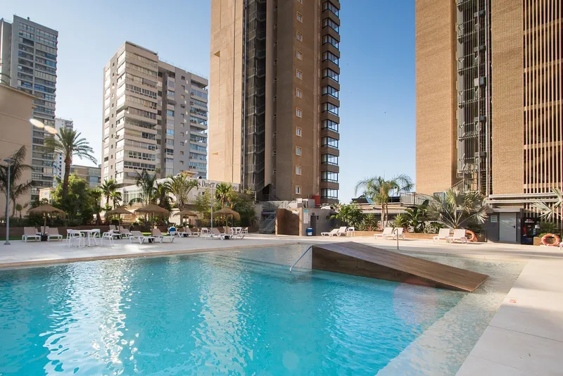 Les Dunes Comodoro: Pool terrace, Pool and sun terrace with palms and loungers below the hotel tower