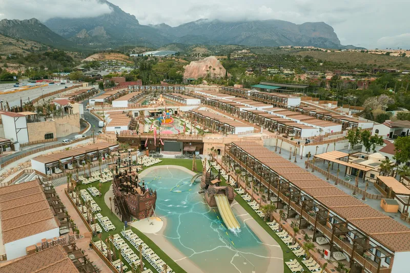 Magic Pirates: The resort, Aerial view of the lagoon pool among low-rise blocks and mountains