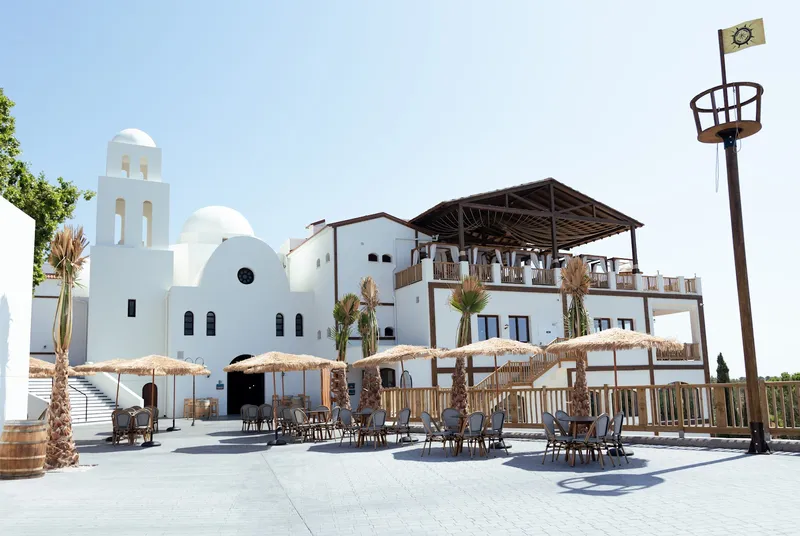 Magic Pirates: Plaza terrace, White domed buildings with tables under straw parasols