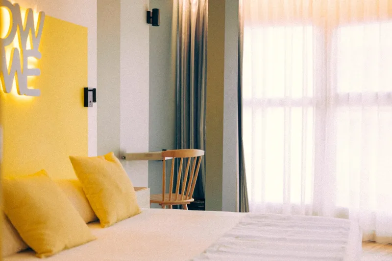Marina Resort: Double room, Bed with yellow cushions by bright windows