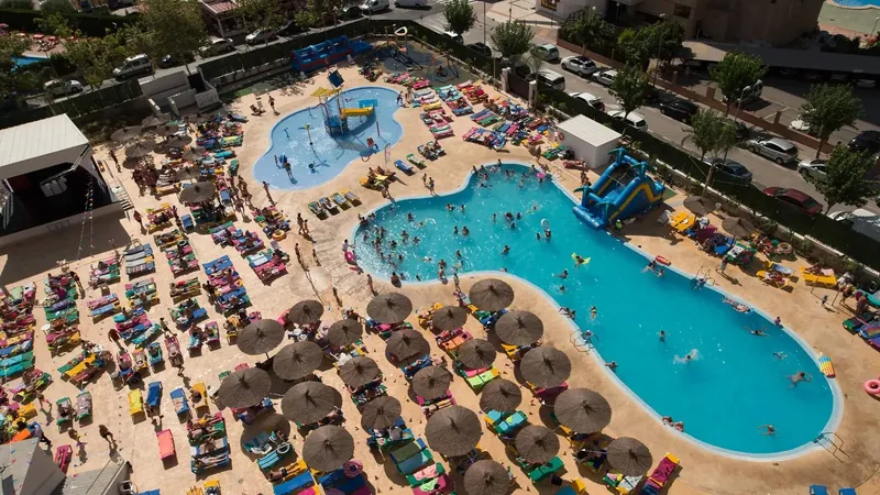 Hotel Rio Park: The pool from above, Lagoon pool ringed by thatched parasols and sunbeds