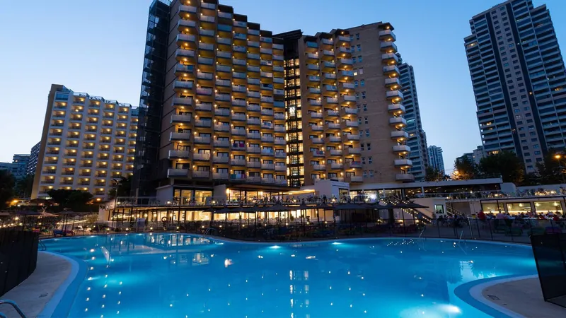 Hotel Rio Park: The main pool at dusk, Lit pool in front of the hotel towers