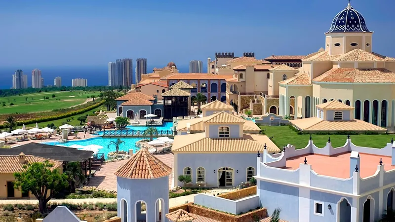 Villaitana: The resort, Resort buildings and pools with a golf course and distant towers