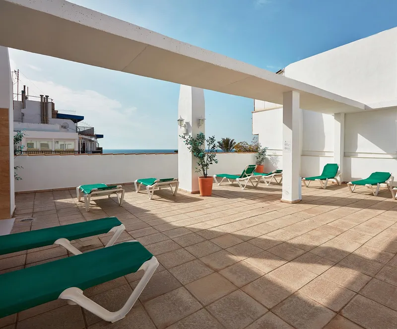 Milord's: Sun terrace, Roof terrace with green loungers and a glimpse of the sea