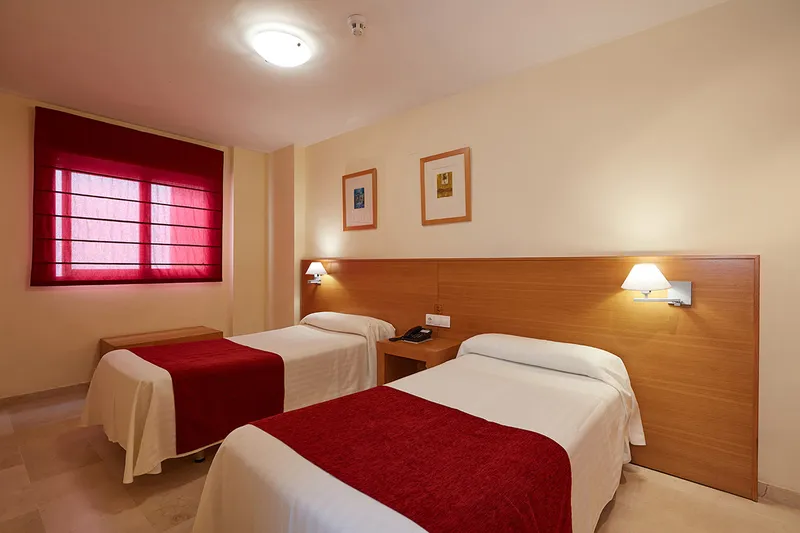Milord's: Twin room, Twin beds with red throws and wooden headboard