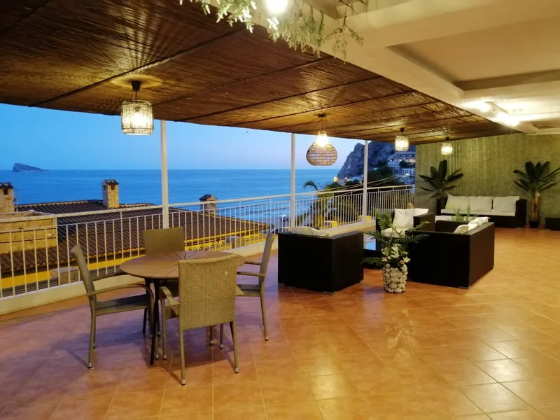 Mirador: Covered terrace, Terrace with dining table and rattan sofas above the bay