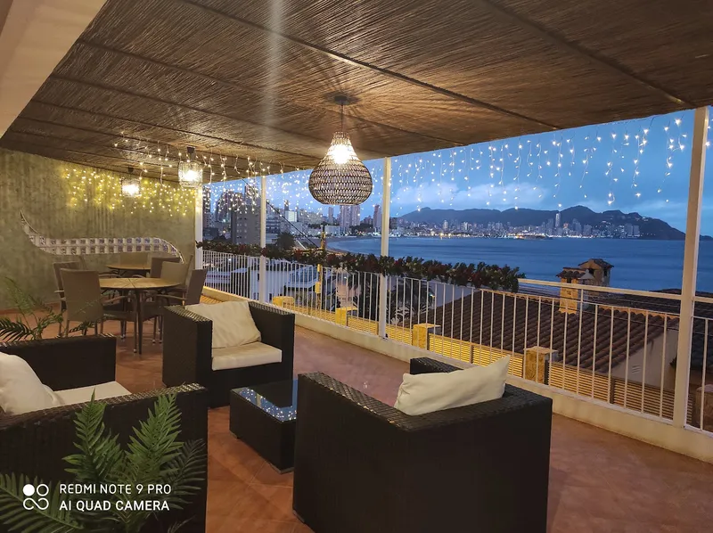 Mirador: Terrace at night, Lounge seating under fairy lights with the city across the bay