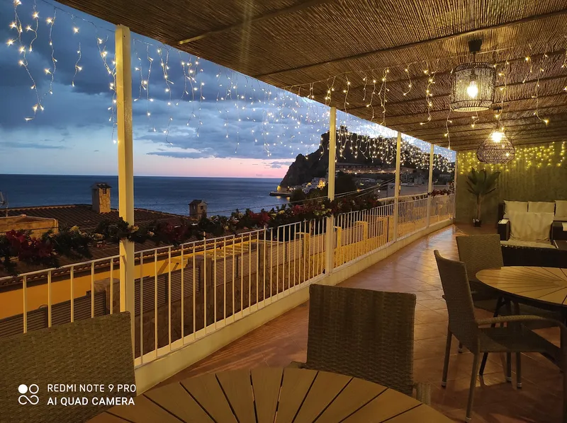 Mirador: Terrace at dusk, Fairy-lit terrace with tables looking out to sea